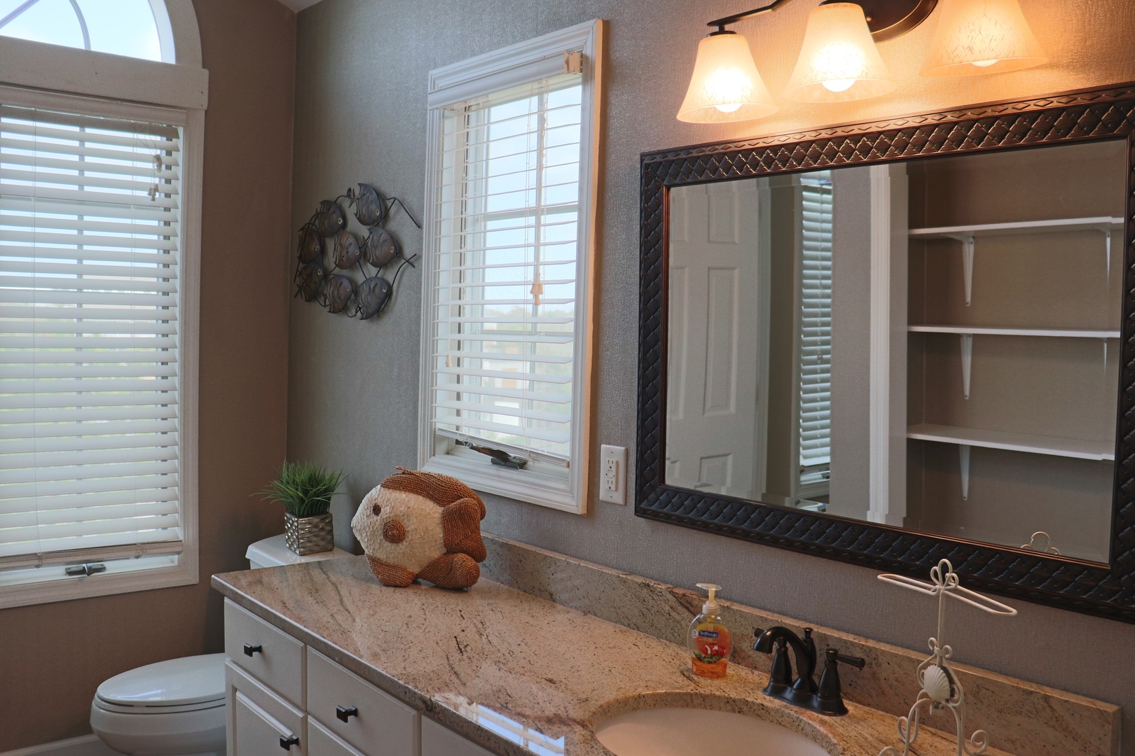 Start your mornings in this beautifully appointed bathroom featuring granite countertops, elegant lighting, and thoughtful details that make getting ready a pleasure.