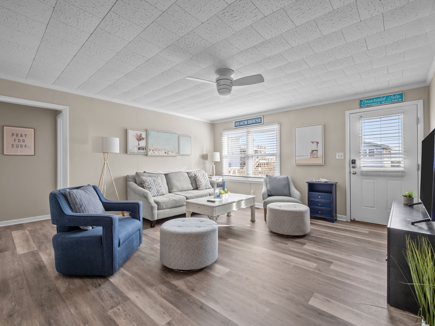 Sink into plush sofas and stylish chairs in your bright living room, complete with coastal art and modern amenities for perfect relaxation.