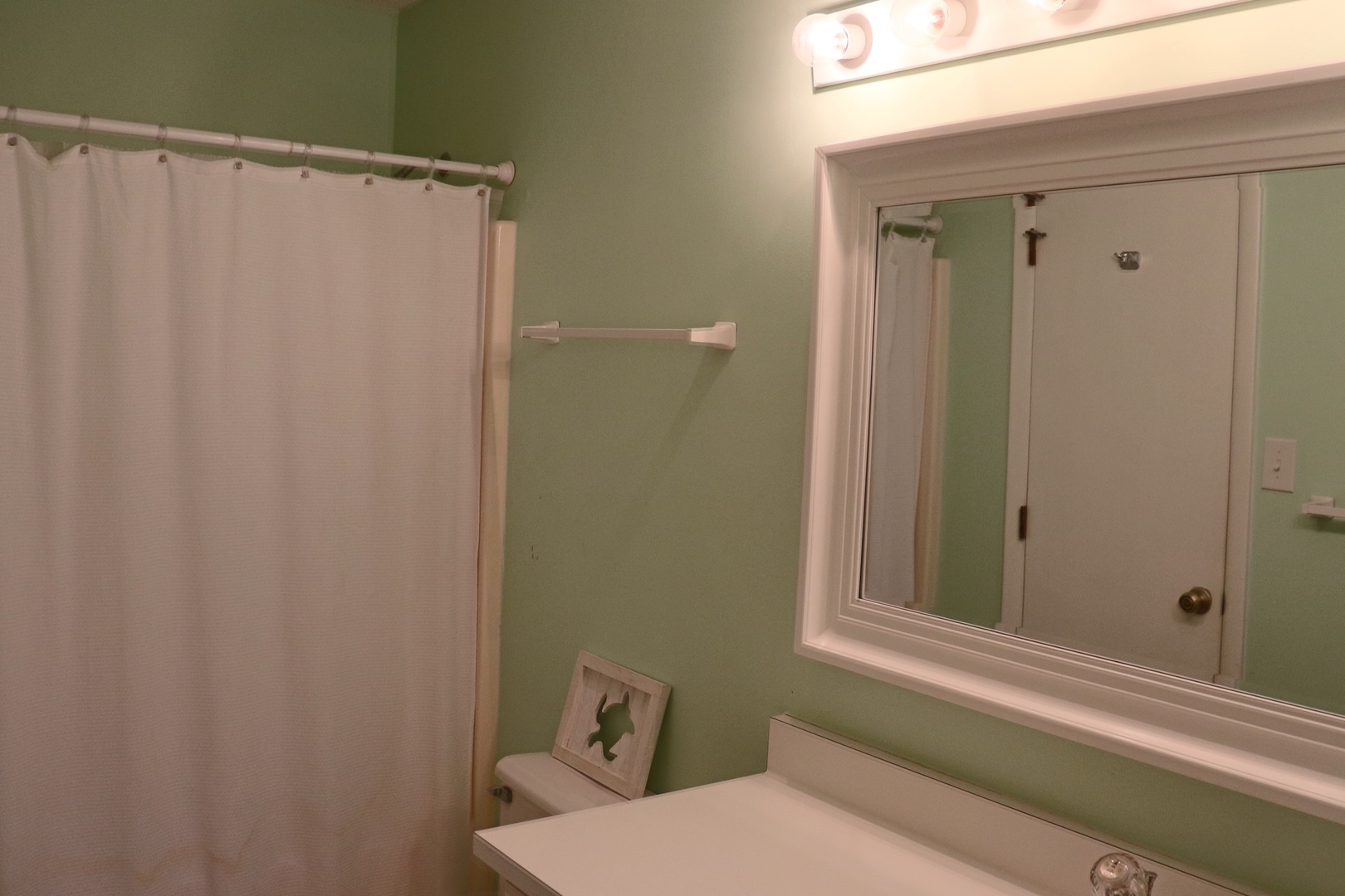 Your private bathroom features soothing sage walls and bright vanity lighting, creating a refreshing space to start your day.