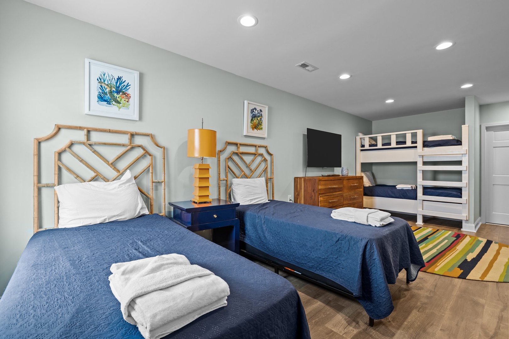 Rest comfortably in your spacious bedroom with twin beds, bunk beds, and coastal artwork creating a relaxing retreat for the whole family.