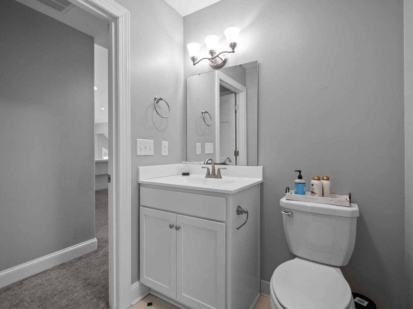 Your private bathroom features crisp white cabinetry, modern fixtures, and thoughtful amenities to start your day refreshed.