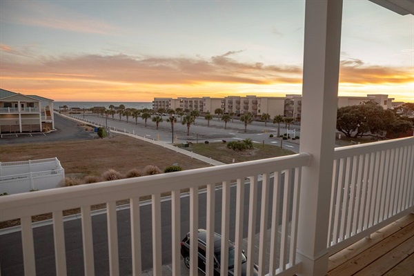 A stunning sunset view from your private balcony over nearby buildings and streets.