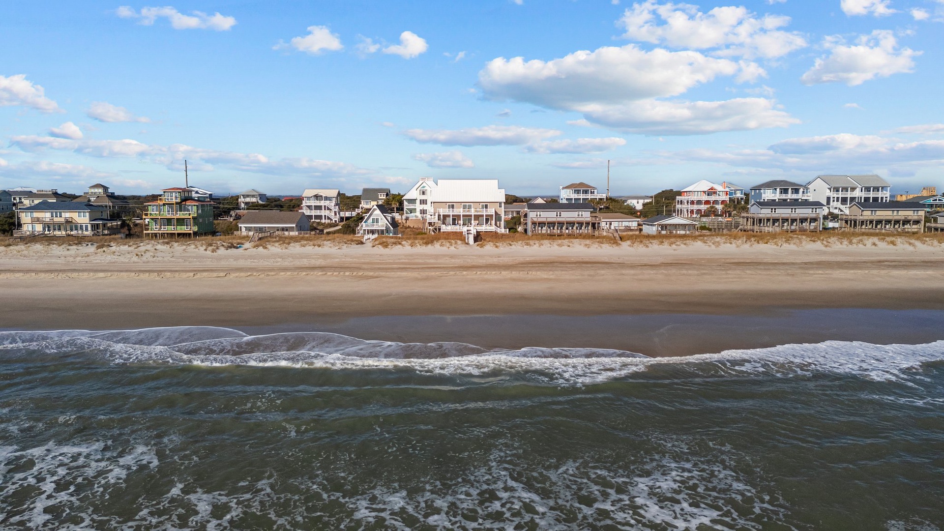 Beachfront vacation homes line the pristine coastline, offering direct access to sandy shores and endless ocean views.