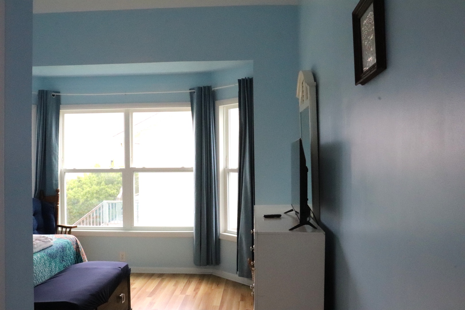 Bright windows flood your room with natural light, while a cozy bed and modern TV set the stage for peaceful mornings and relaxing evenings in your own serene retreat.