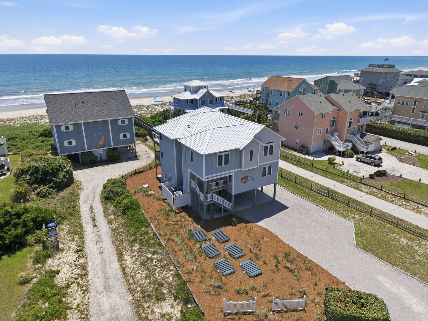 Beachfront property located steps from the sandy shore, surrounded by coastal homes with ocean access and neighborhood parking.