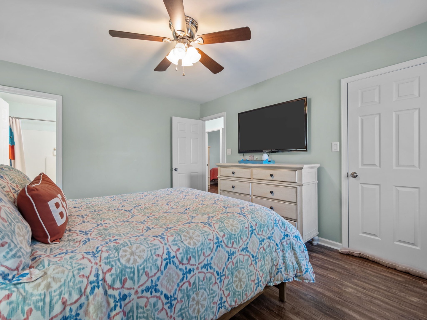 Drift off in your serene bedroom with soft mint walls, coastal bedding, and gentle ceiling fan creating the perfect sleep sanctuary.