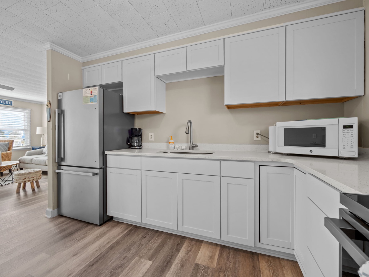 Your fully equipped kitchen features sleek white cabinets, stainless steel appliances, and everything you need to prepare meals during your stay.