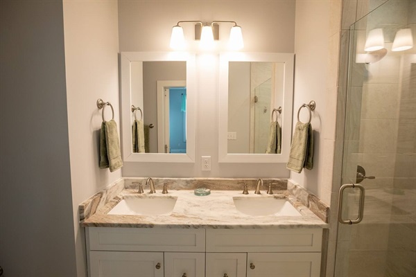 Your beautifully updated bathroom features dual vanities with elegant marble countertops and modern fixtures for your comfort.