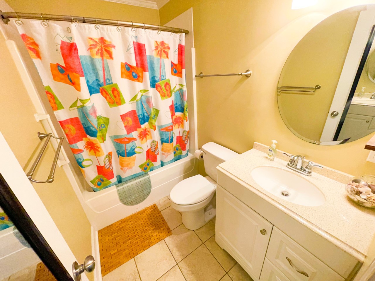 Bright bathroom with tropical shower curtain and warm yellow walls creates your cheerful morning routine space.