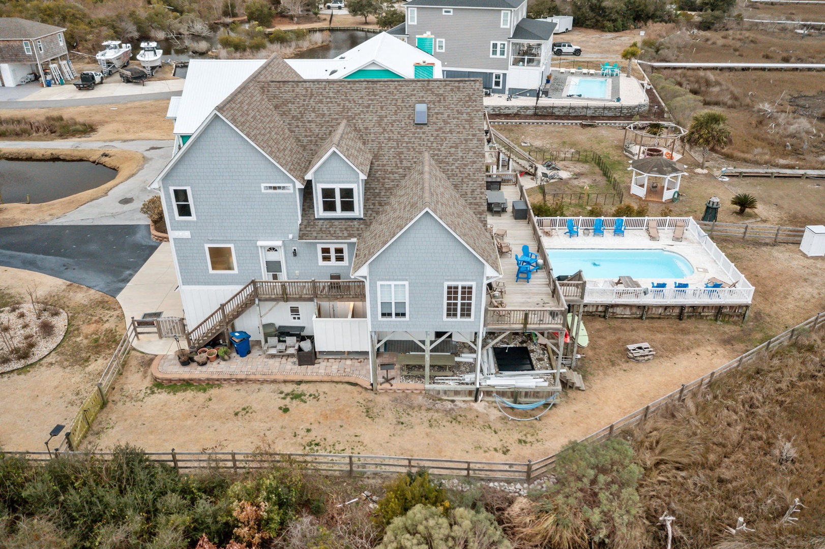 Aerial view showcasing the property's coastal location with private pool, waterfront access, and spacious outdoor entertaining areas.