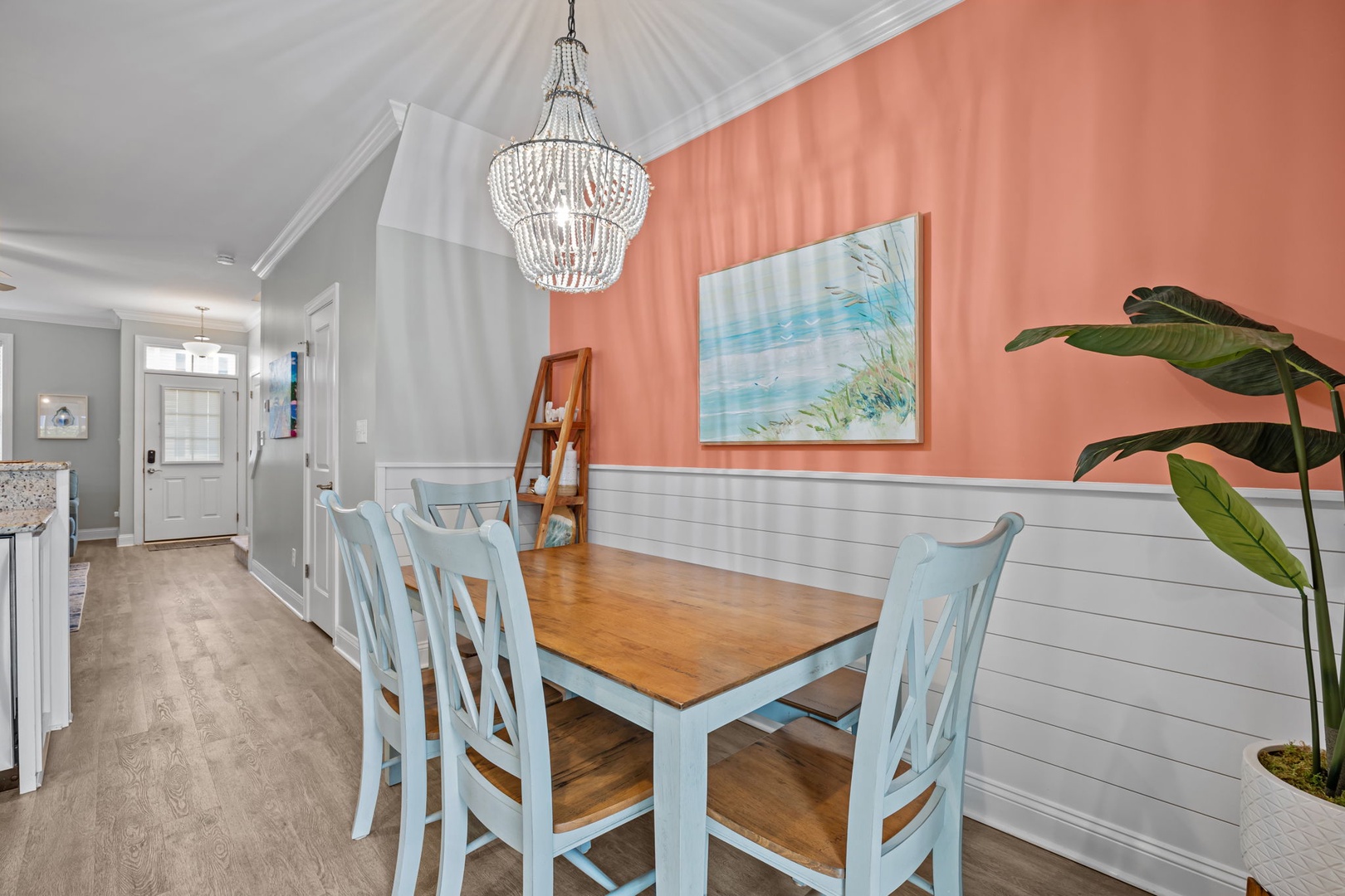 Your charming dining space features coastal-inspired decor with elegant chandelier lighting, perfect for memorable meals together.