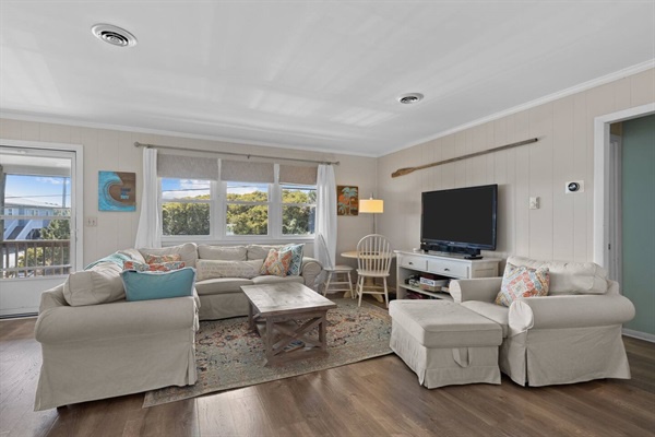 Unwind in your bright living room with plush seating, coastal views, and modern entertainment for perfect relaxation after beach adventures.