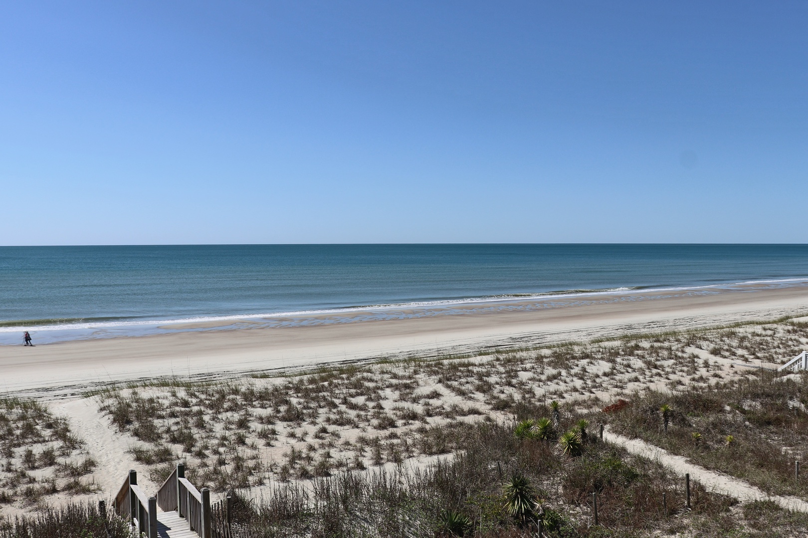 Pristine beachfront with endless ocean views and pristine sandy shores stretching along the coast.