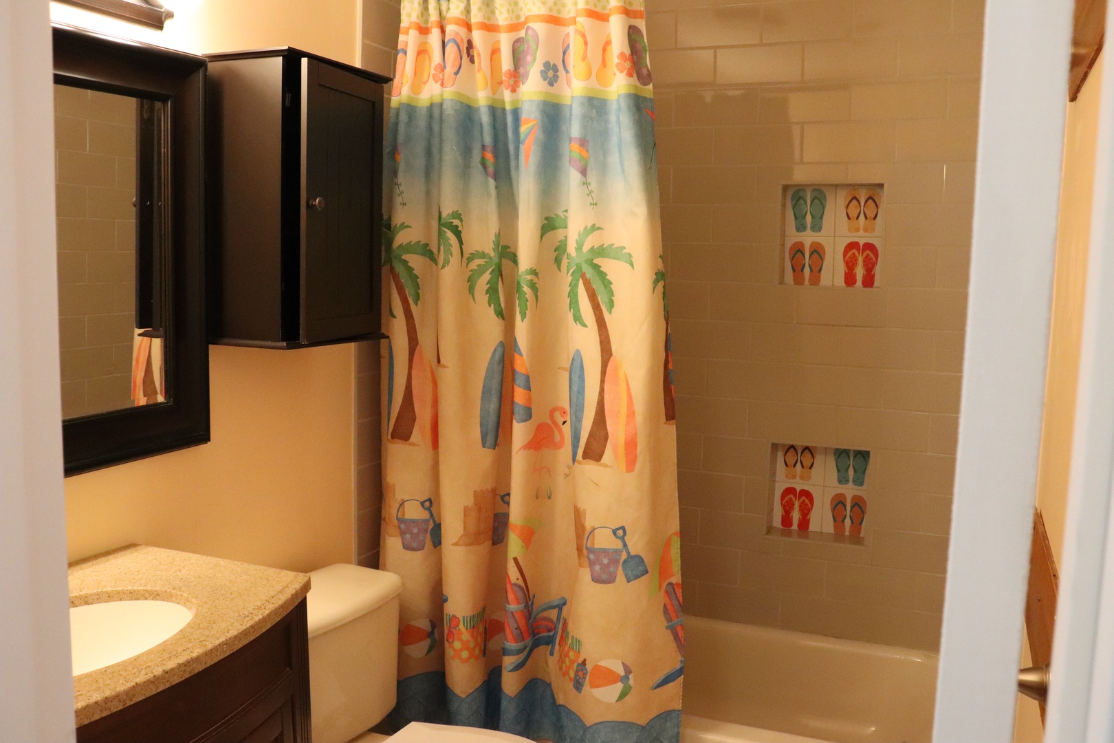 Brighten up after a day of adventure in your cheerful bathroom featuring a beach-themed shower and convenient storage for all your essentials.