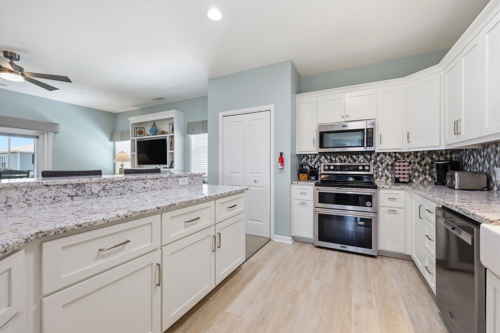 You'll love preparing meals in this bright, open kitchen with gleaming granite counters, stainless steel appliances, and beautiful tile backsplash—perfect for gathering with family and friends.