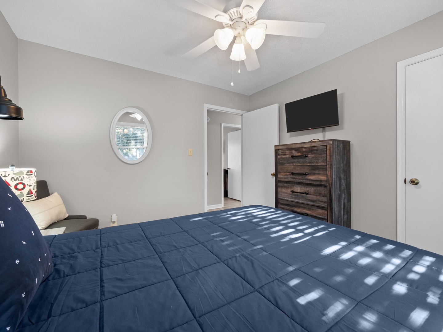 Drift off peacefully in your bright bedroom with comfy bedding, wall-mounted TV for movie nights, and rustic dresser for all belongings.