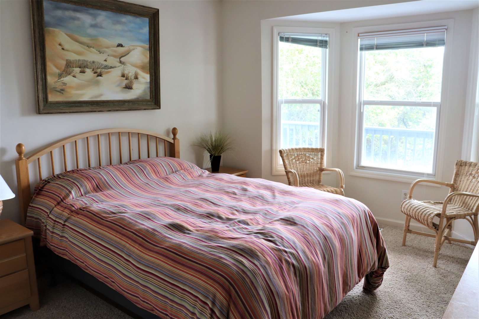 Wake up to natural light streaming through your bedroom windows, with cozy wicker chairs perfect for morning coffee and peaceful garden views.