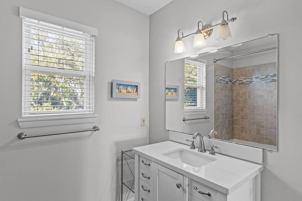 Your private bathroom features elegant vanity with ample storage, stylish tile shower, and natural light streaming through windows.