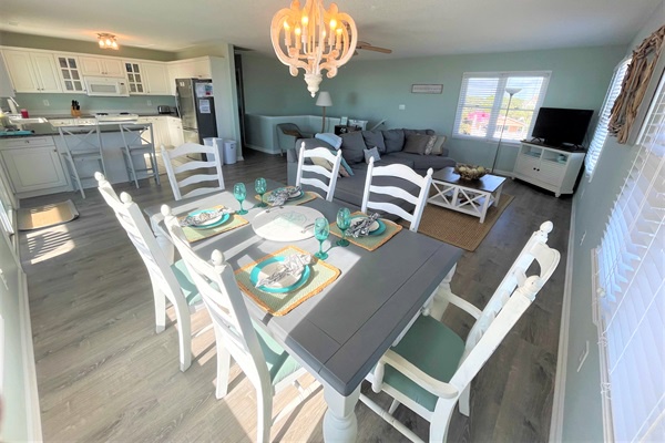 Gather around this elegant dining table where memories are made over delicious meals, with natural light streaming through windows.