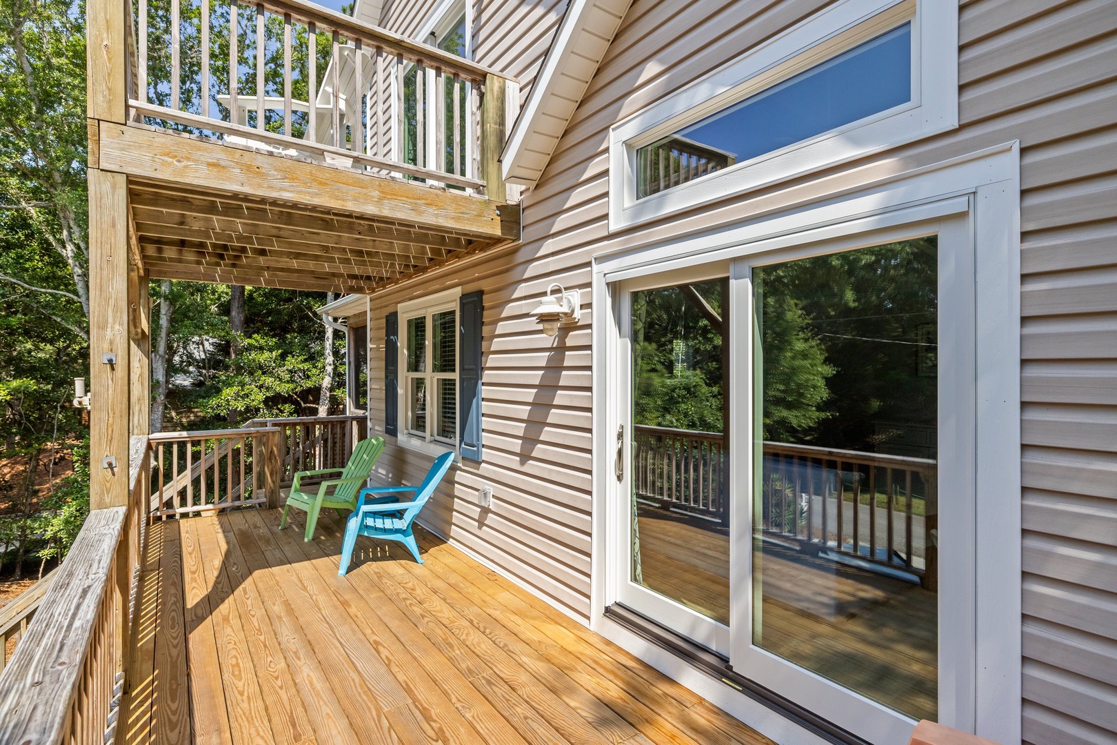 Step onto your private deck surrounded by lush trees, where colorful chairs await your morning coffee or evening relaxation.