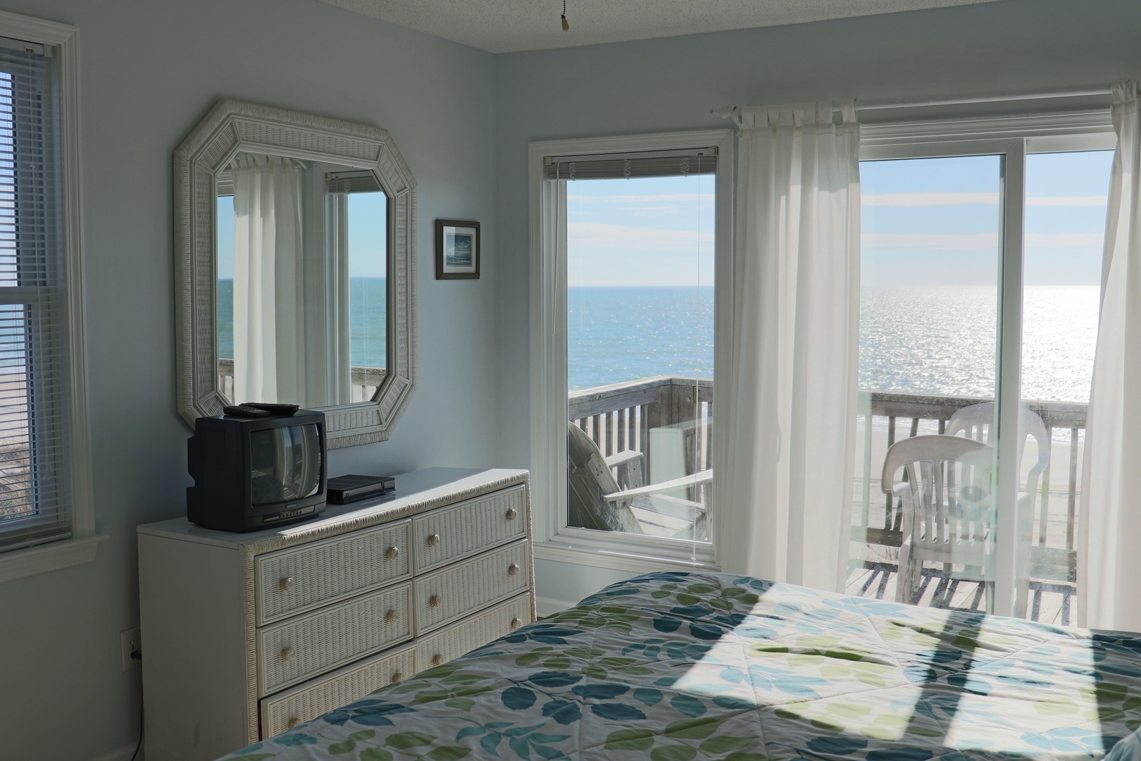 Wake to ocean waves through your floor-to-ceiling windows. Your seaside bedroom features soothing coastal décor and direct balcony access to endless sea views.