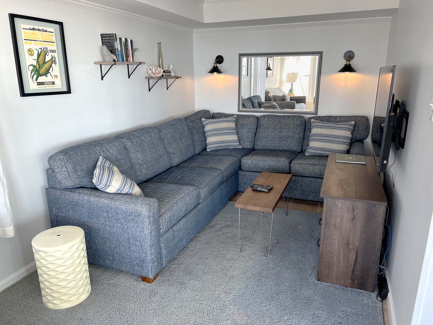 Sink into this cozy sectional where warm lighting and thoughtful touches create the perfect spot for your evening unwind.
