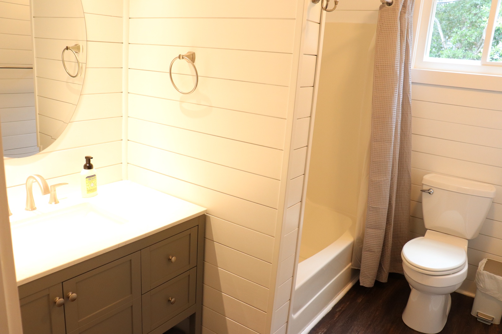 Refresh in your charming bathroom with warm wood walls, a deep soaking tub, and modern amenities for a cozy retreat.