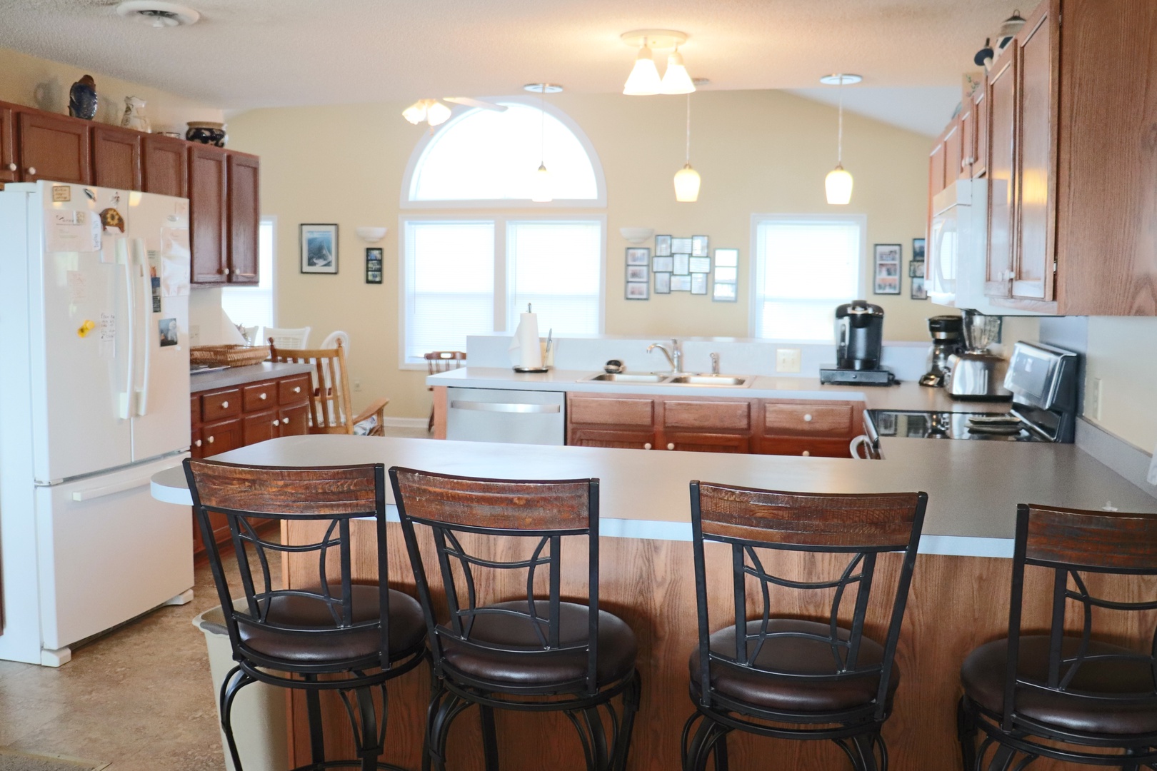 Your spacious kitchen welcomes you with warm wood cabinets, modern appliances, and a breakfast bar where morning coffee tastes even better.