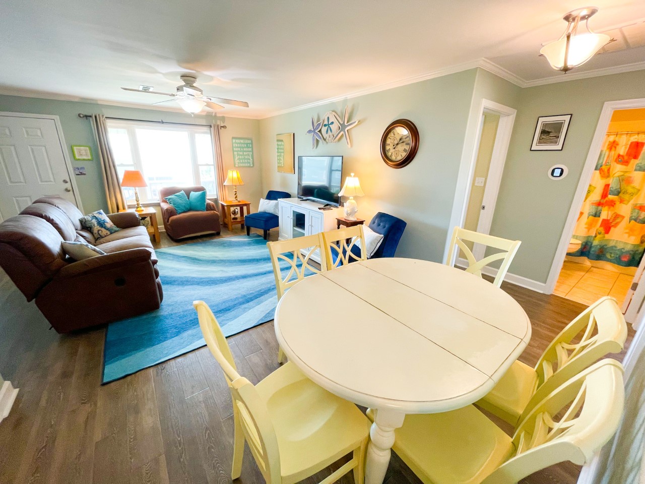 Relax in your bright, coastal-themed living space with comfy seating, flat-screen TV, and cheerful dining area perfect for family meals.