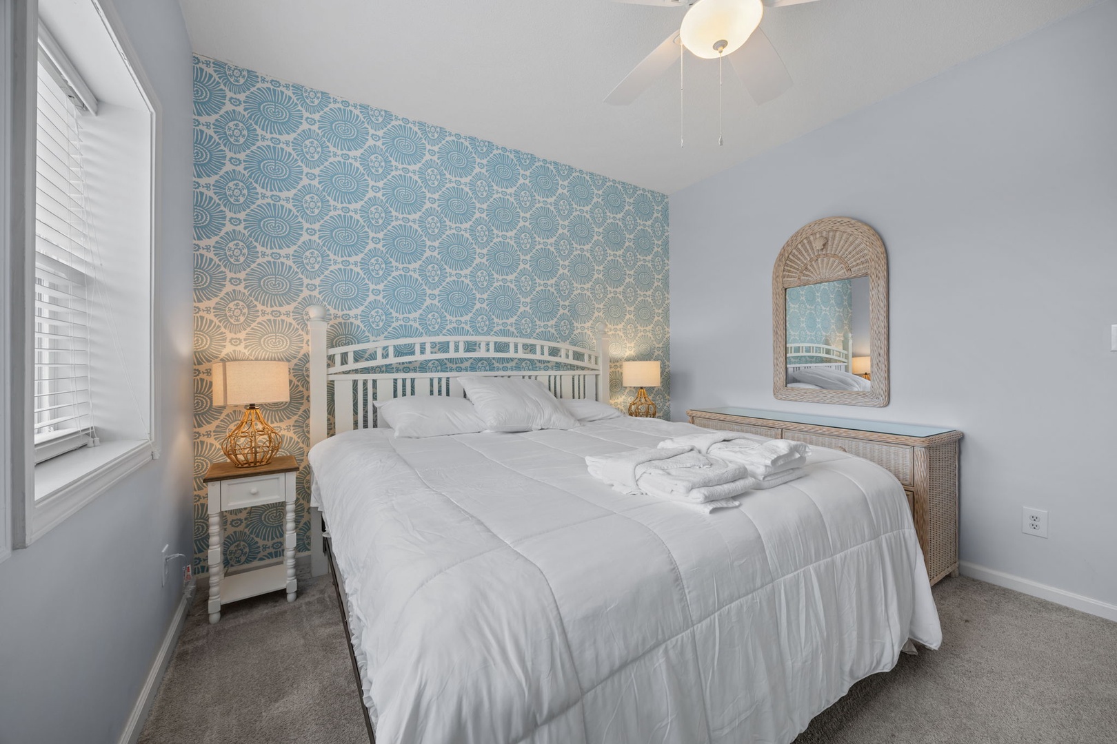 Drift into peaceful dreams in your coastal-inspired bedroom, where soft blue wallpaper and crisp linens create the perfect seaside sanctuary.
