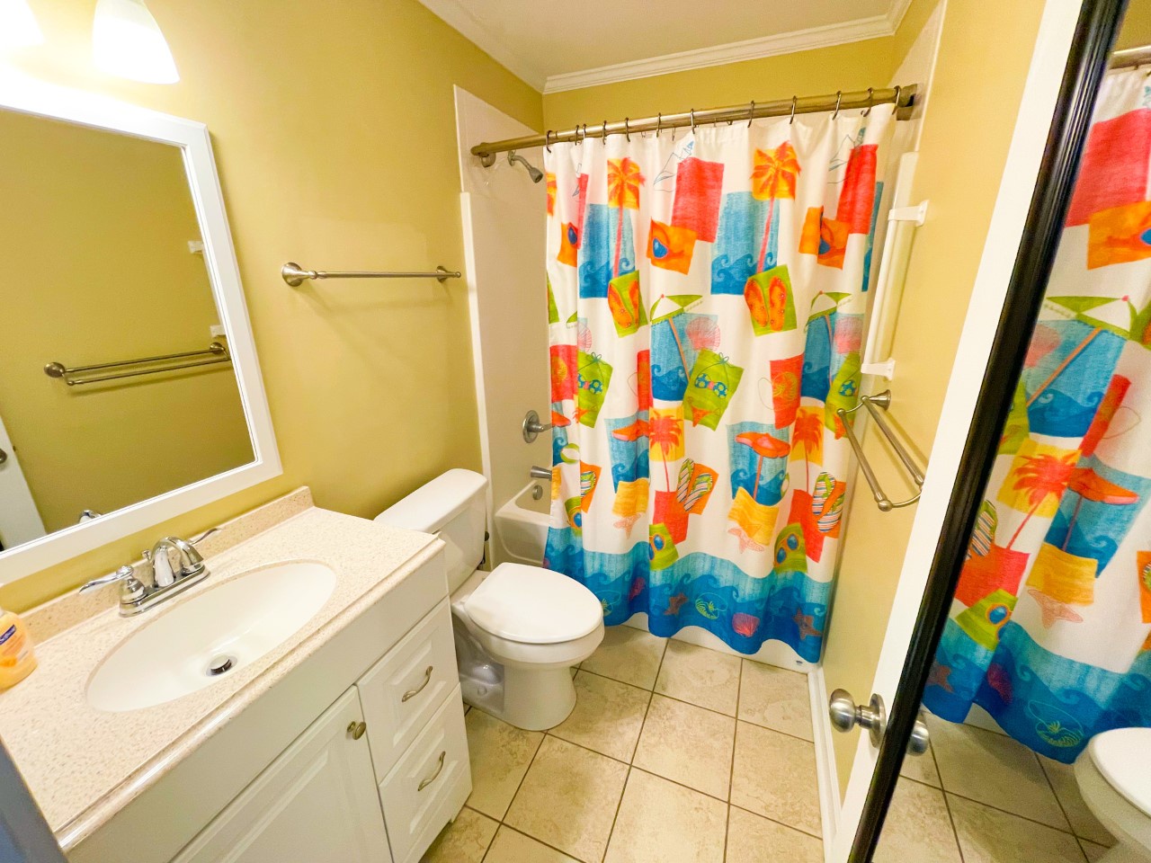Step into your bright, cheerful bathroom featuring tropical-themed décor that instantly puts you in vacation mode.