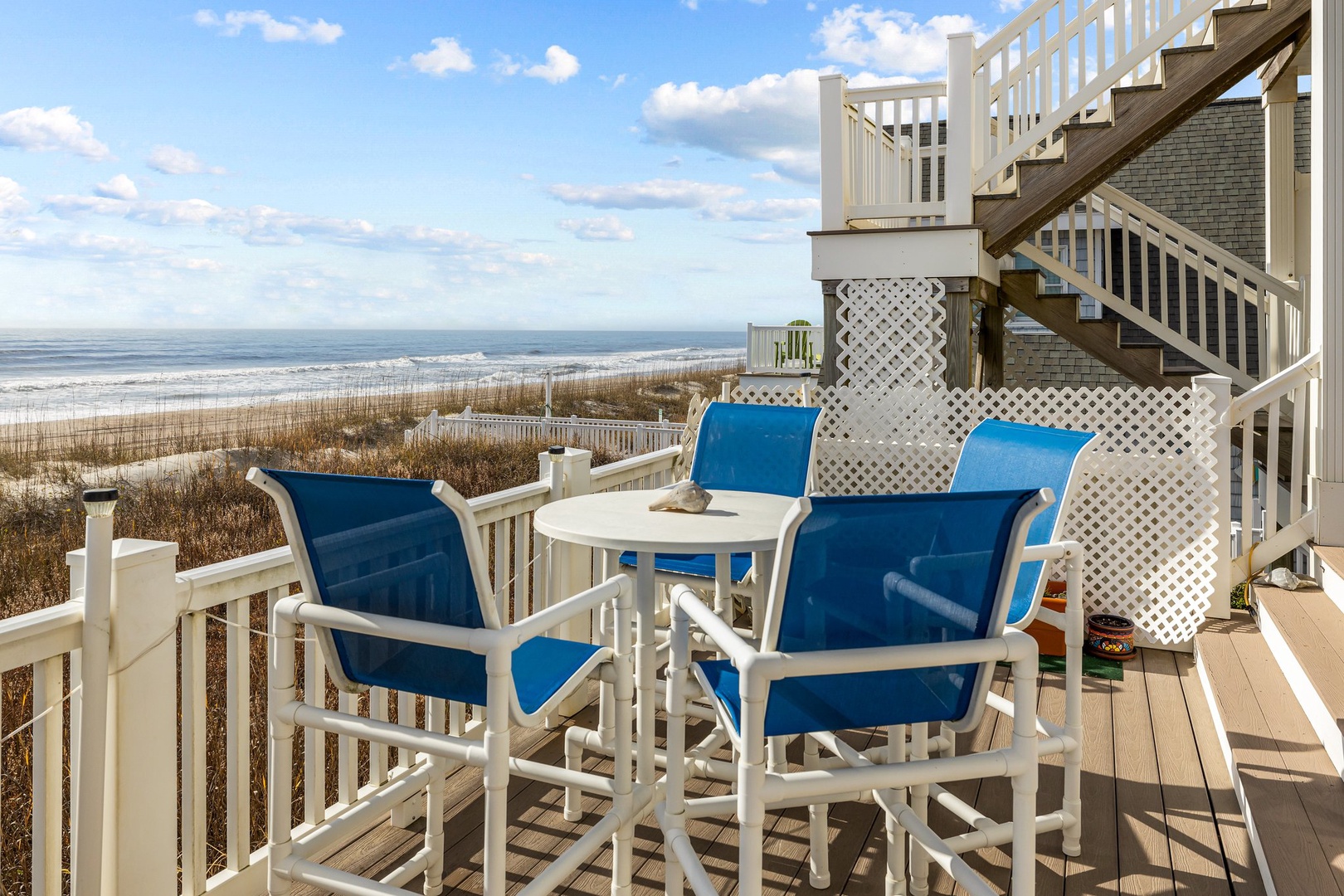 Enjoy morning coffee or sunset cocktails from your private deck, where blue cushioned chairs frame endless ocean views.