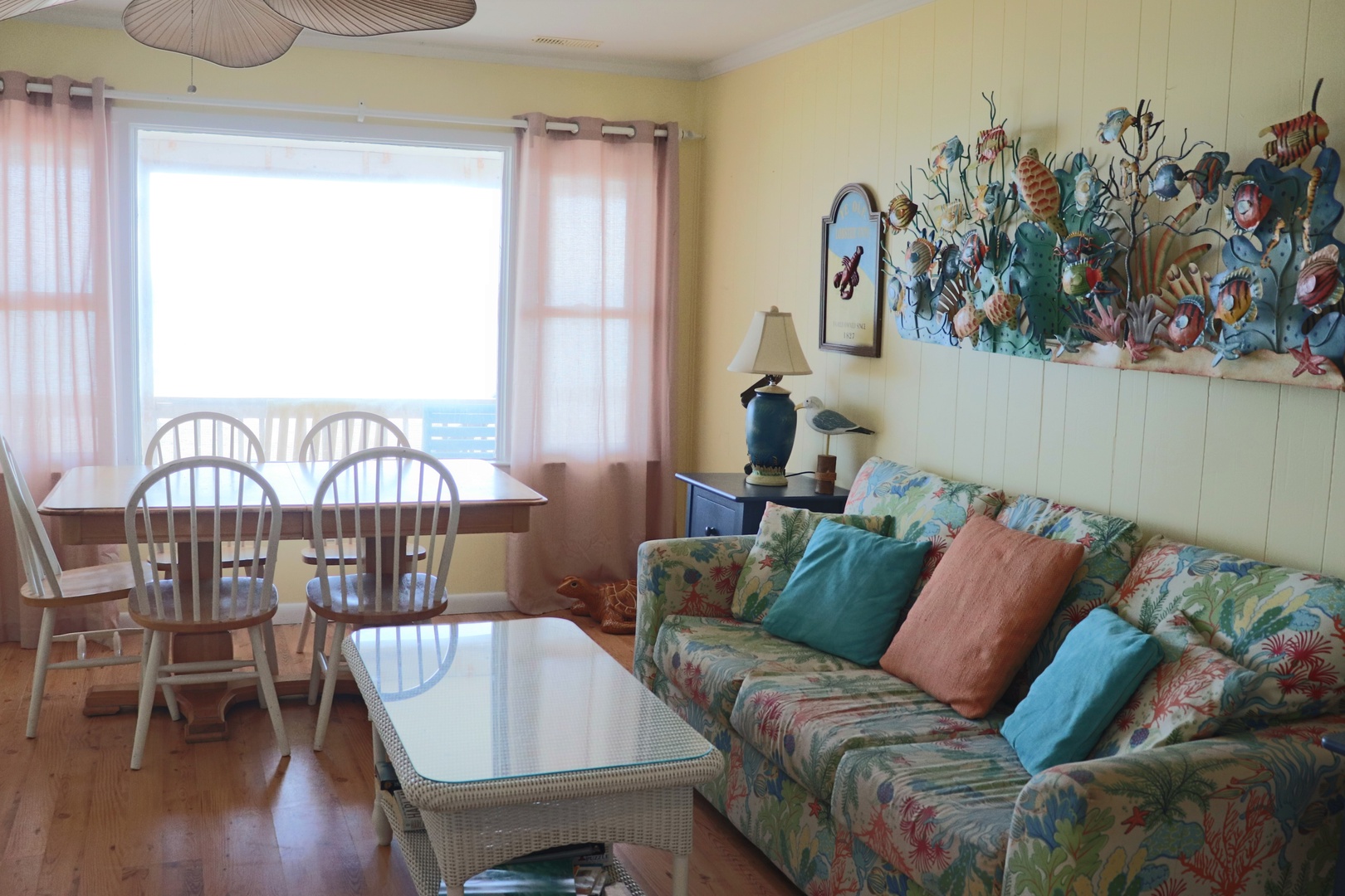 Relax in your vibrant ocean-themed living space, where tropical colors and sea life murals create a cheerful coastal atmosphere for memorable vacation moments.