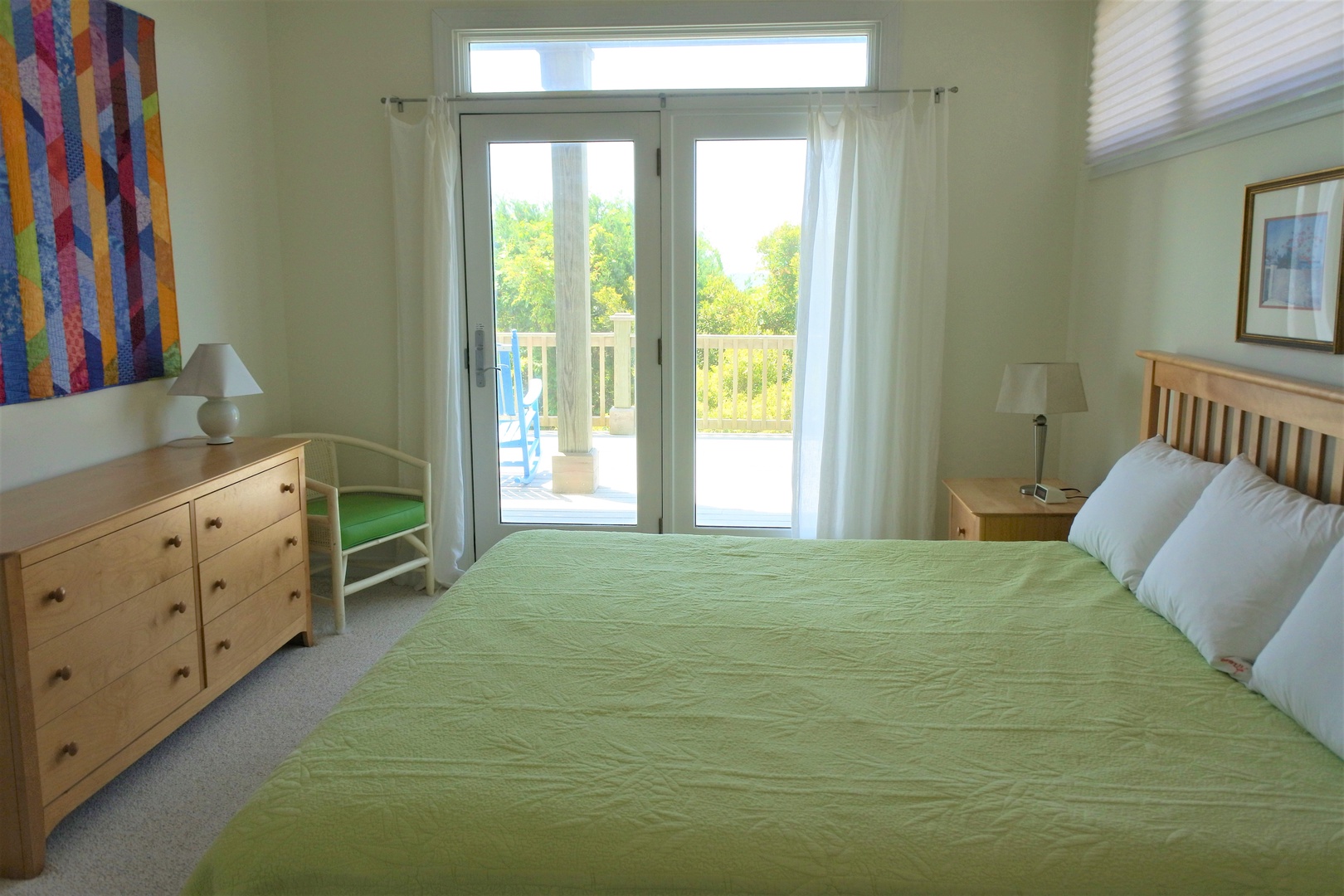 Wake up to natural light streaming through your private balcony doors in this serene bedroom with fresh green linens and peaceful garden views.