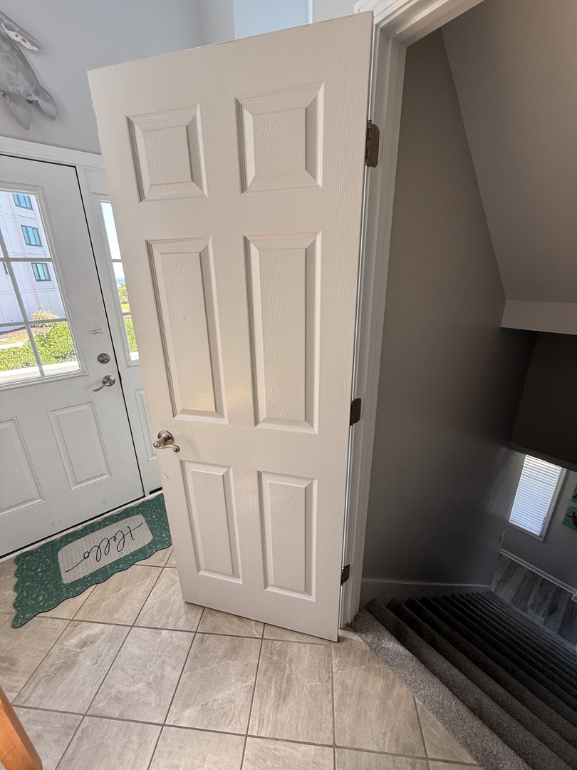 The property features a clean, welcoming entrance with neutral tones and textured tile flooring leading into a modern entryway—your first glimpse of home away from home.