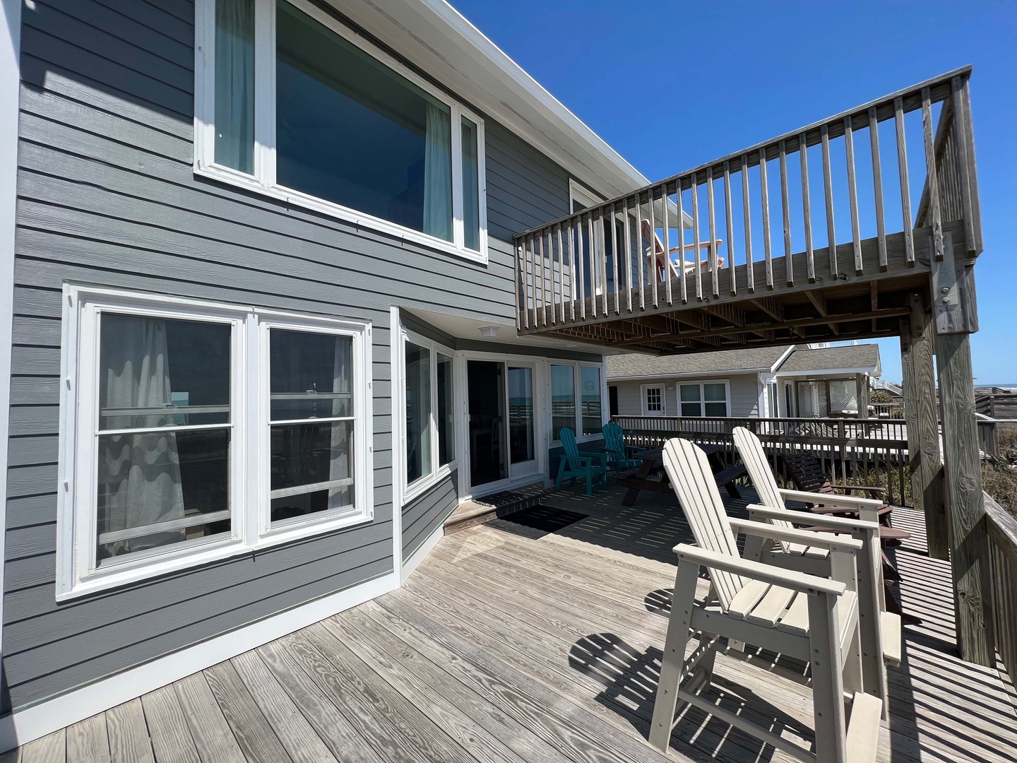 Expansive deck with Adirondack chairs where you can relax and soak up the coastal sunshine, with multiple levels for lounging.