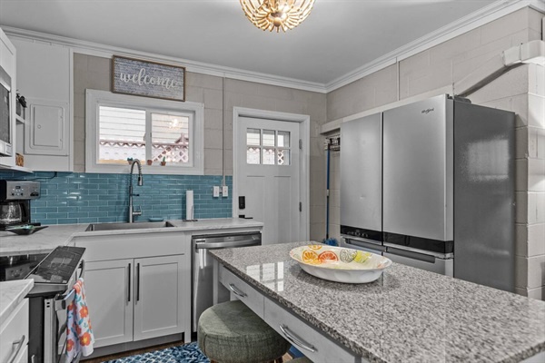 Gather around your fully equipped kitchen featuring granite countertops, stainless steel appliances, and charming blue subway tile backsplash for memorable meal prep.