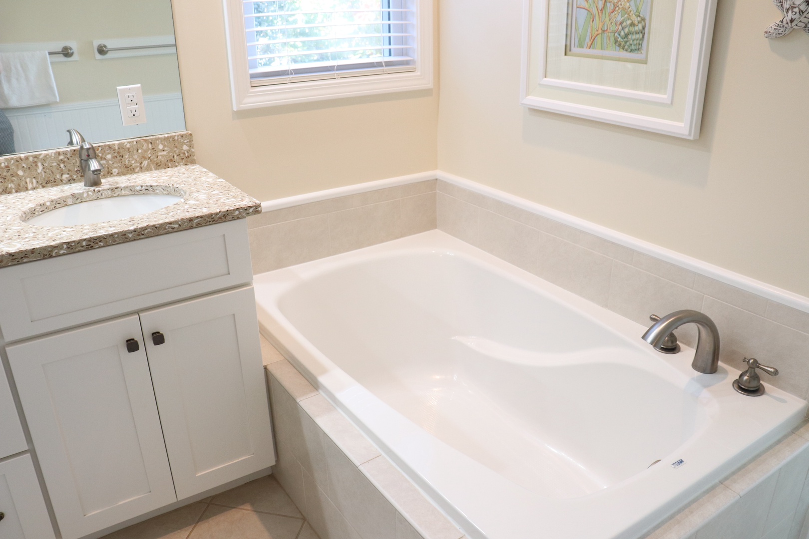 Unwind in your pristine bathroom featuring a deep soaking tub and elegant granite vanity—perfect for relaxing after exploring the area.