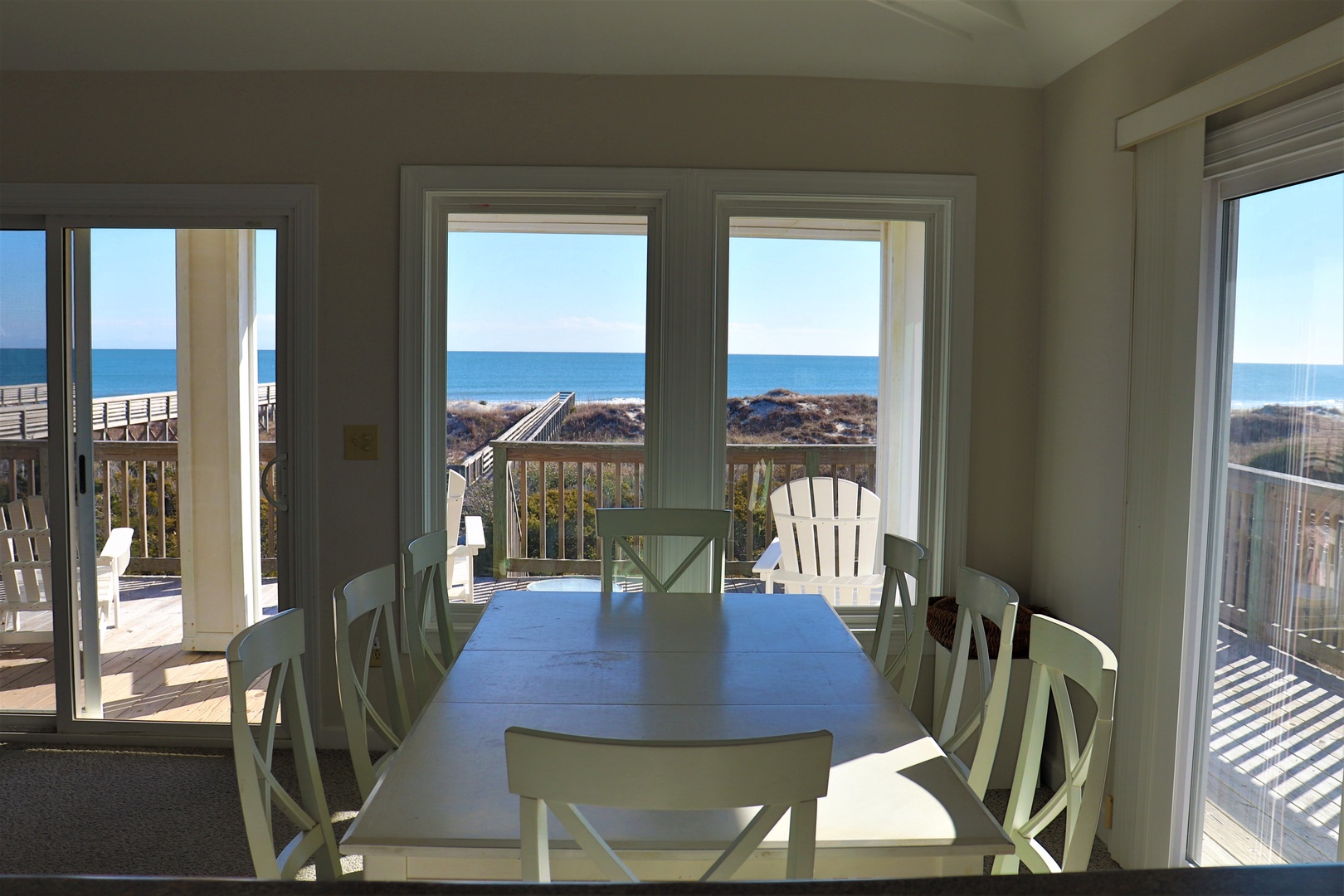 Savor your morning coffee at this inviting dining table while gazing at the endless ocean views through floor-to-ceiling windows.