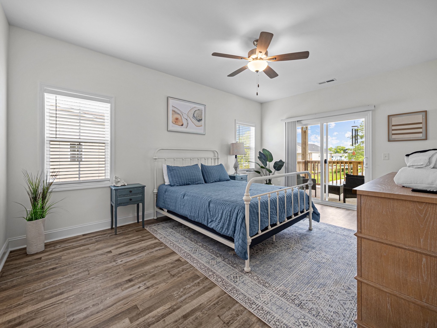 Relax in your bright bedroom with cooling ceiling fan, balcony access, and peaceful views for restful nights.