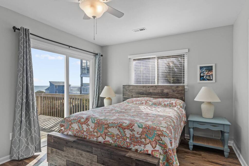 Wake up to coastal views from your comfortable bedroom with rustic wood accents and private balcony access.