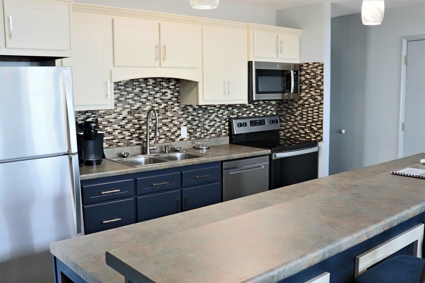 Your fully equipped kitchen features stainless appliances, granite countertops, and a stylish mosaic backsplash—perfect for creating memorable meals during your stay.