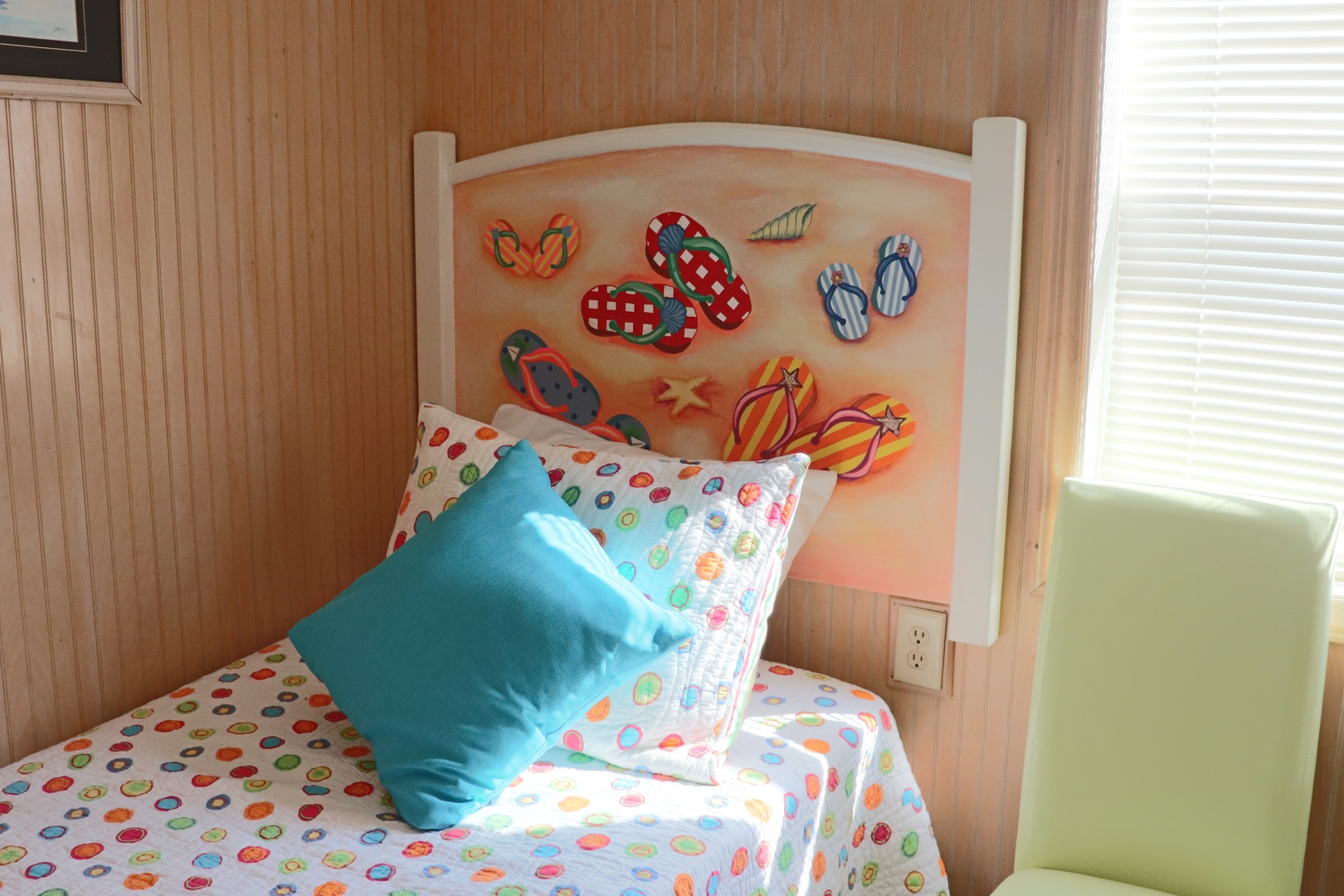Your cozy bedroom features a unique flip-flop headboard and playful polka dot bedding that creates a cheerful, beachy vibe for restful nights.