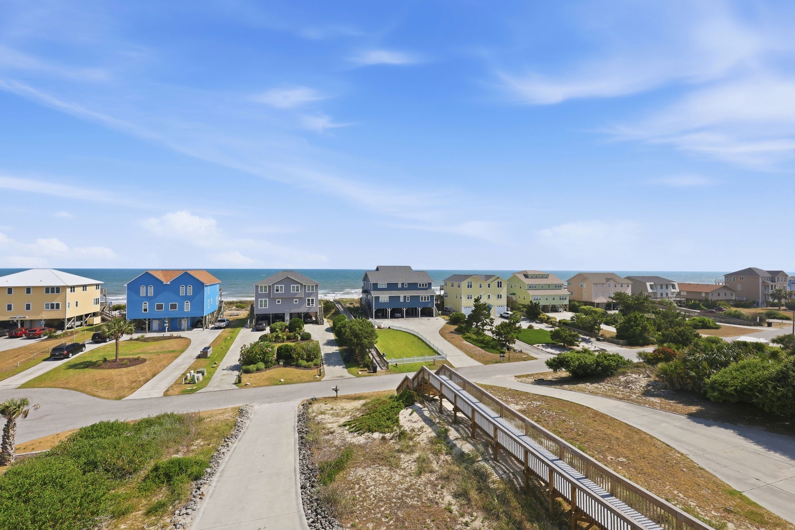 A coastal neighborhood with colorful beach houses and ocean access, located just steps from the sandy shoreline and surf.