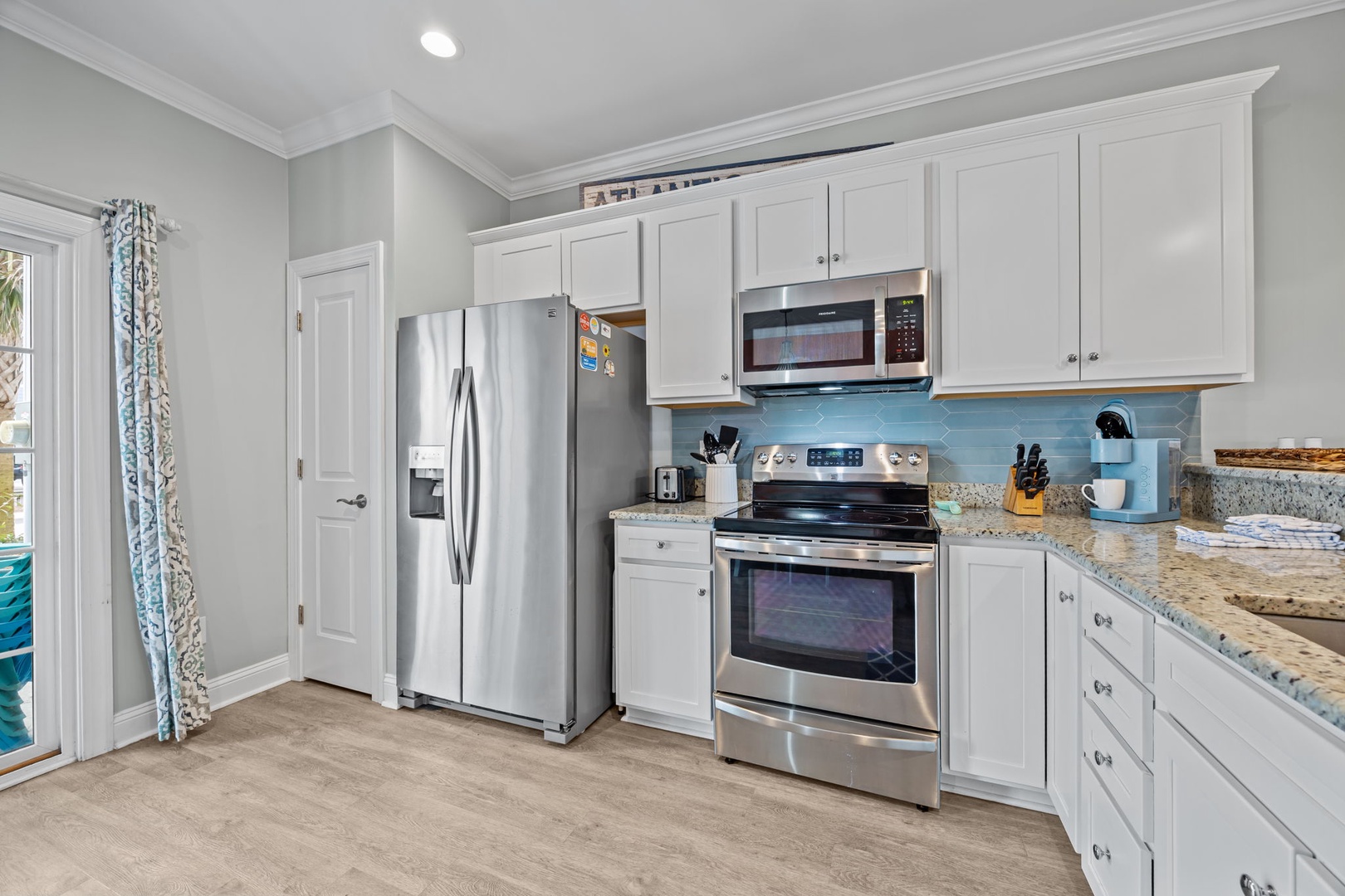 Your fully equipped kitchen features granite countertops, stainless steel appliances, and bright coastal colors for your culinary adventures.