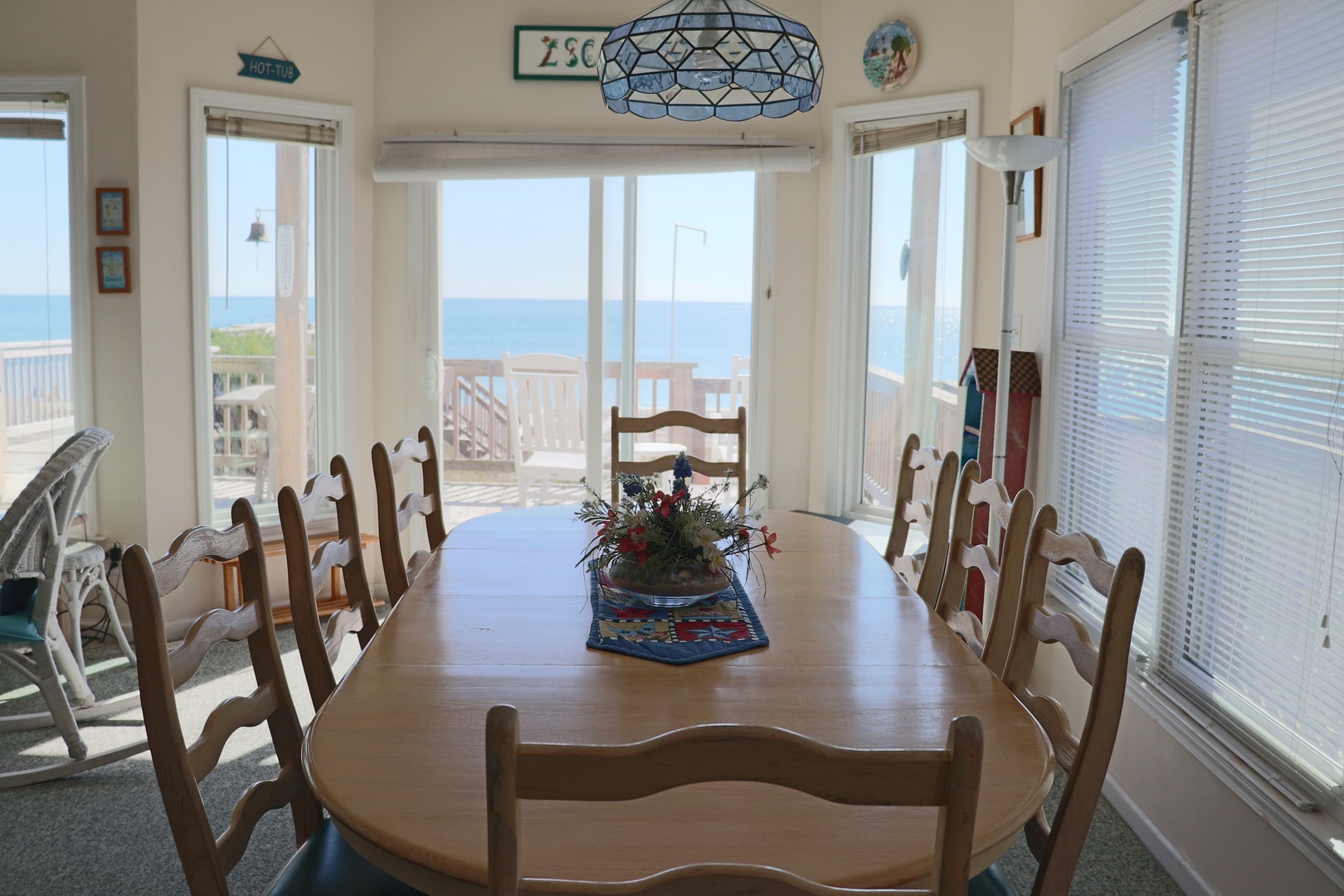 Gather around this inviting wooden dining table where your meals come with stunning sea views through expansive windows.