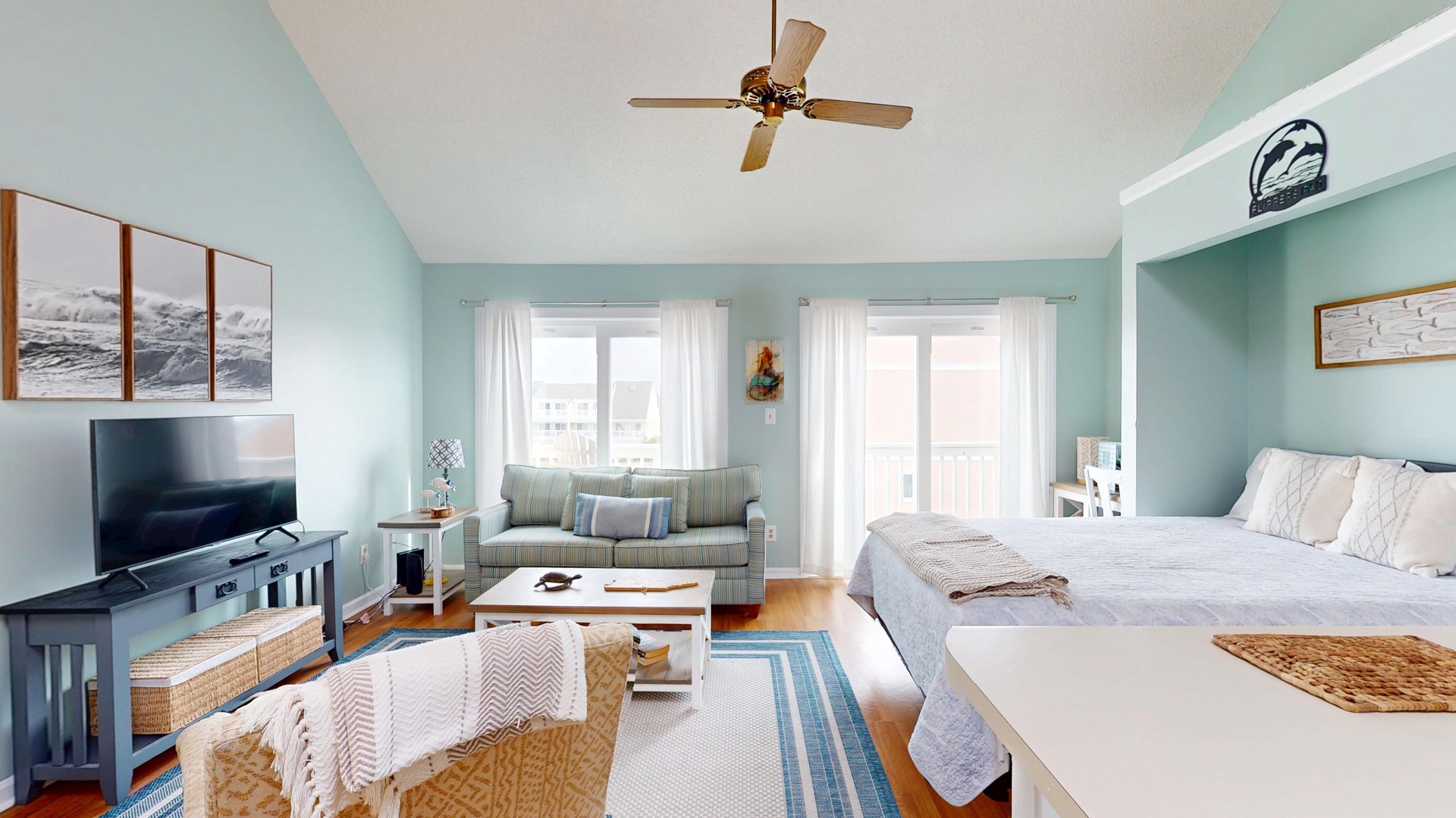 Your serene coastal studio blends sleeping and living areas with calming blues, natural textures, and modern comfort for the perfect beach getaway.