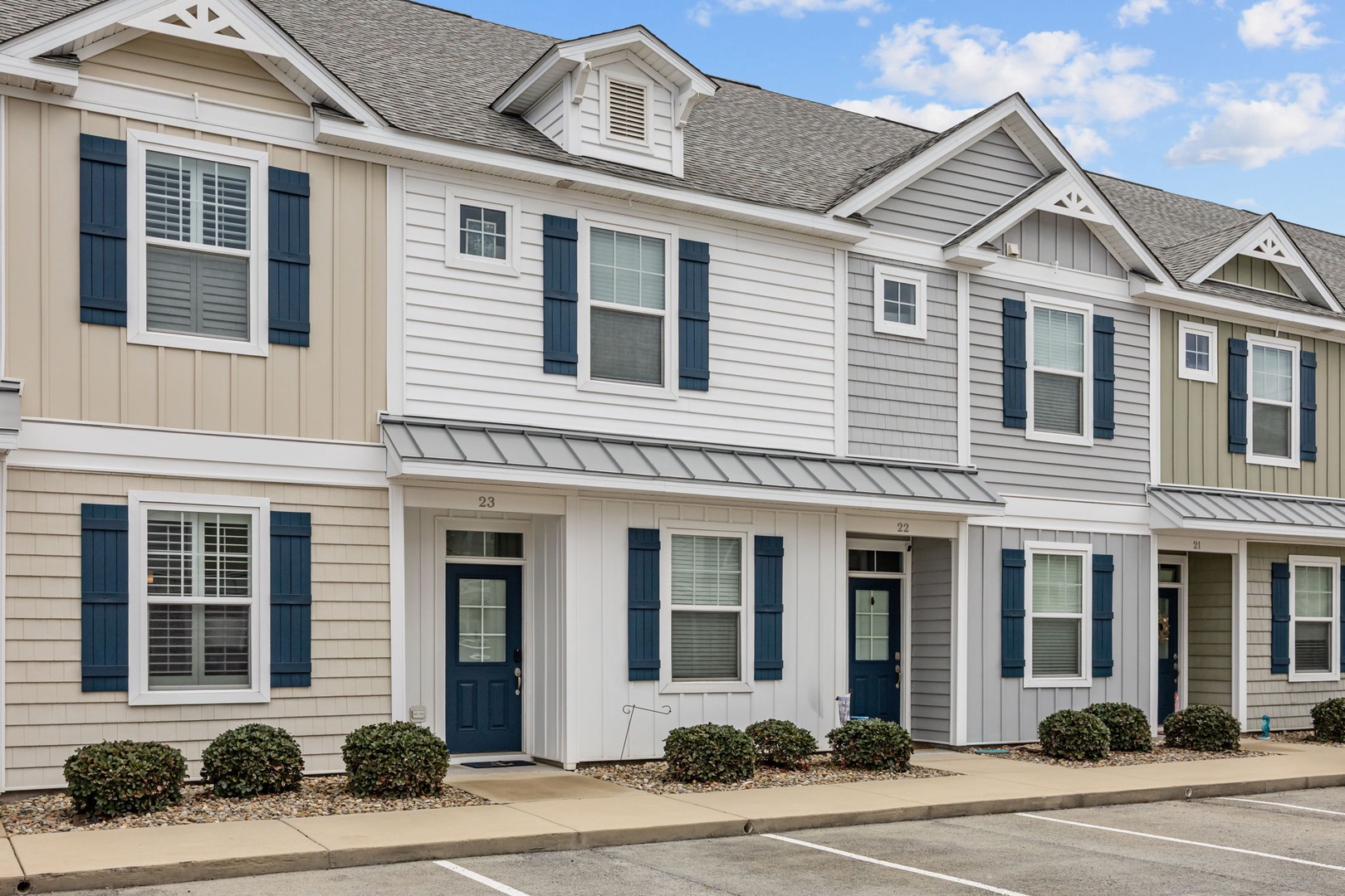 Modern townhomes with charming architectural details and convenient parking create an inviting neighborhood setting.