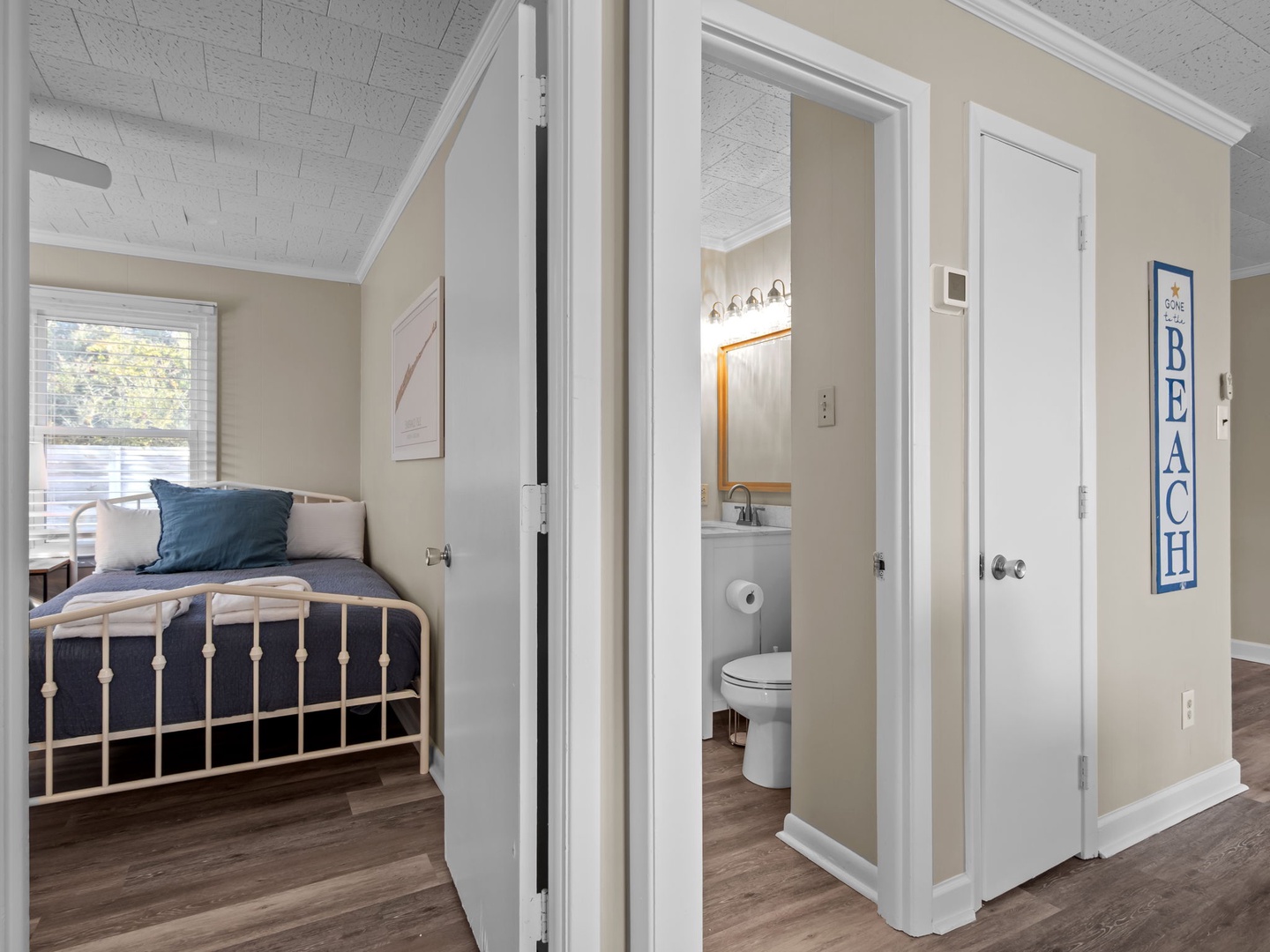 Your cozy bedroom retreat features a charming white iron bed, while the private ensuite bathroom offers modern convenience just steps away.