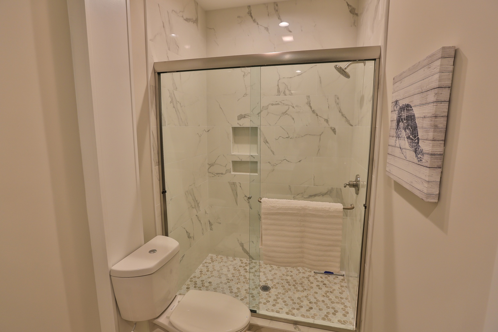 Step into your sleek bathroom featuring a luxurious glass shower with marble-inspired walls and modern fixtures for your comfort.